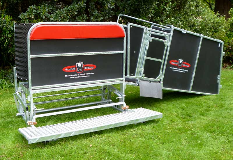A modern, red sheep handling clamp system in a yard